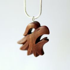 a wooden pendant is hanging from a chain on a white background with the image of an oak leaf