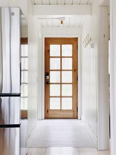 an open door leading to a kitchen with stainless steel appliances