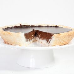 a piece of chocolate pie on a white cake plate