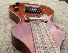 a wooden guitar laying on top of a bed