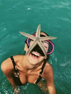 a woman in the water with a starfish mask and goggles on her head