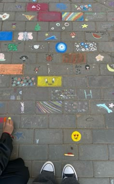 someone is standing on the sidewalk with their feet up and there are many stickers all over the ground