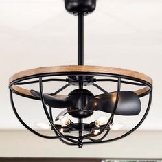 a black ceiling fan with wooden blades and two lights on it's sides, hanging from the ceiling