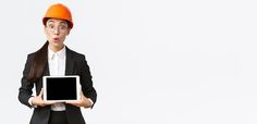 a woman wearing an orange hard hat holding a tablet computer in front of her face