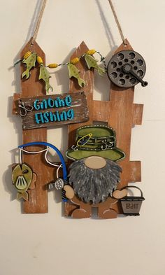 a wooden sign with various items hanging from it's sides and the words ground fishing on them