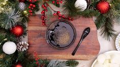 a wooden cutting board topped with lots of christmas decorations and food on top of it