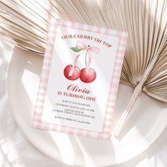 a cherry themed birthday party with pink gingham paper and an open fan on the table