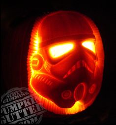 a star wars pumpkin carved to look like darth vader's helmet with glowing eyes