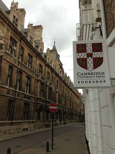 the cambridge book shop sign is posted on the side of the building next to the street