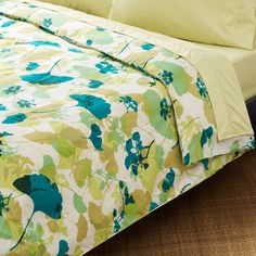 a bed with green and blue flowers on it