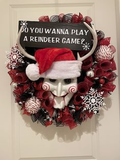 a wreath with a santa hat on top of it and a sign that says do you wannaa play a reindeer game?