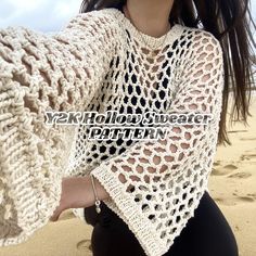 a woman wearing a white crochet sweater on the beach