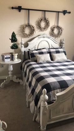 a bed with two wreaths on the wall above it and a table in front of it