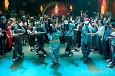 a group of people standing on top of a blue floor in front of a crowd