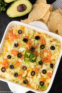 an appetizer dish with tortilla chips and avocado on the side