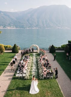 a bride and groom walking down the aisle to their wedding ceremony at lake comoni