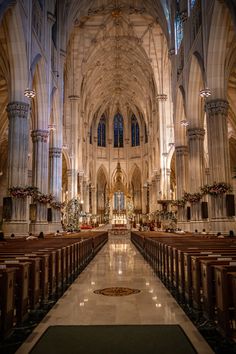 the inside of a cathedral with pews and lights