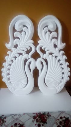 two white sculptures sitting on top of a table