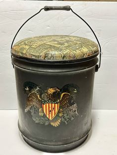 an old metal bucket with two eagle emblems on it