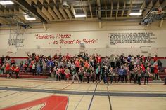 a group of people standing on top of a basketball court in front of a crowd