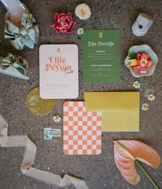 various items are laid out on the floor to be used as wedding stationery and decorations