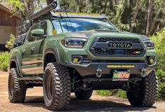 a green toyota truck parked on top of a dirt road