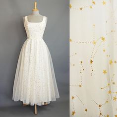 Our star gazer dress is made from layers of soft floaty tulle which features a metallic gold celestial pattern that shimmers in the light. The square scoop bodice and ballerina length circle skirt offer an understated nod to the 1950s while maintaining the flattering shape that our customers love. The tulle is overlaid on to a cotton poplin base for a dress that is light and comfortable to wear all day. Fastening at the back with a concealed zip, the dress is fully lined with cotton on the bodic Wedding Dress Ankle Length, Celestial Wedding Dress, Dig For Victory, Celestial Pattern, Dress Ankle Length, Above Elbow, Celestial Wedding, Long Torso, Circle Skirt