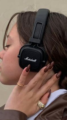 a woman with her headphones up to her ear