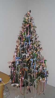 a decorated christmas tree with ribbons and lights in the shape of an xmas tree