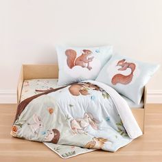 a bed with two pillows on top of it and an animal themed comforter in the middle