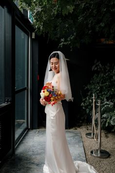 a woman in a wedding dress holding a bouquet