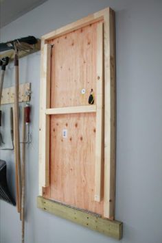 an unfinished window in the wall with tools hanging from it's sides and some wood framing