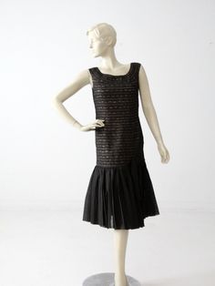 A stunning 1960s vintage drop waist dress. The black lace cocktail dress features a fitted bodice with a drop waist and layered chiffon skirt. A slouched bow sits on the left hip. The hand-made dress closes up the back with a metal zipper.  CONDITION In good condition with wear consistent with age and use. There are a few very minor fly aways in the lace.  Approximate Fit:  US 4 or 6 MEASUREMENTS Bust:  36" ...  91.4 cm Hips:  38" ... 96.5 cm Length:  41.5"  ...  105.4 cm HOW WE MEASURE * Dress Victorian Shoes, Fur Dress, Black Lace Cocktail Dress, Lace Cocktail Dress, Drop Waist Dress, Flapper Style, Lace Dress Black, Dropwaist Dress, Cocktail Dress Lace