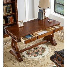 a wooden desk with drawers underneath a lamp