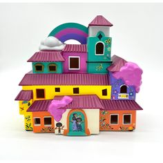 a toy house with lots of windows and decorations on the roof, sitting in front of a white background