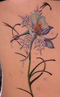 a woman's back with a flower tattoo on it