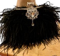 Ebony Black Real Ostrich Feather clutch handbag,  Done with a clutch that the inside is Silver satin with a Crystal drop jewel in silver setting with clear crystal stones on the front of bag shows a Vintage scrolling design and, a Art Deco style clasp in the form of the half. Stunning fluffy Ebony Black Fringed Ostrich Feathers cover the front and, the back. Purse chain s included inside. Very Glamorous! Hand-Crafted. High-End Bag. THIS BAG IS STUNNING. 🌹PLEASE NOTICE:  These are bags with natural real feathers which some go through a dyeing process depending on the color. That is why the shipping window is from 1 to  2 weeks for delivery. If you need it sooner please add a note to your order so we can accommodate. Thank you This bag a Show Stopper. For the Bride,  1920s Gala, Gatsby Part Wedding Purse, Gatsby Party, Shoulder Chain, Black Fringe, Ostrich Feathers, Art Deco Wedding, Wedding Deco, Gatsby, Clutch Handbag