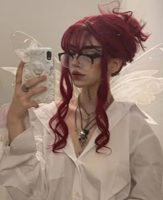 a woman with red hair and glasses taking a selfie