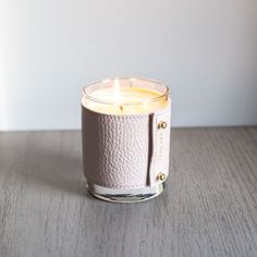 a white candle sitting on top of a wooden table