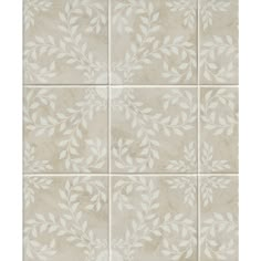 a tile wall with white leaves on the top and bottom tiles in different sizes, shapes and colors