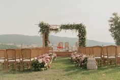 an outdoor ceremony set up with chairs and flowers