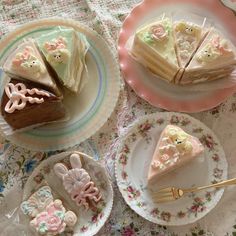 three plates with slices of cake on them sitting on a floral tablecloth covered table