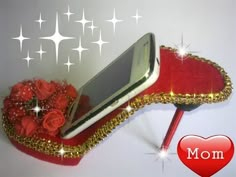 a cell phone sitting on top of a red shoe with roses and stars around it