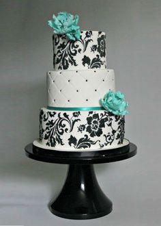 a white and black cake with blue flowers on it