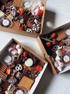 three boxes filled with different types of food and marshmallows on top of each other