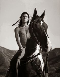 a man riding on the back of a brown horse