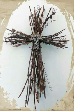 a cross made out of barbed wire sitting on top of a white plate