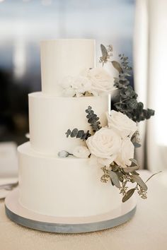 a wedding cake with white flowers and greenery