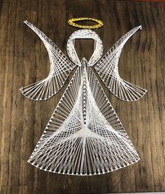 a wire angel ornament sitting on top of a wooden table