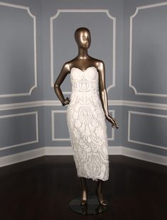 a mannequin wearing a white dress in a room